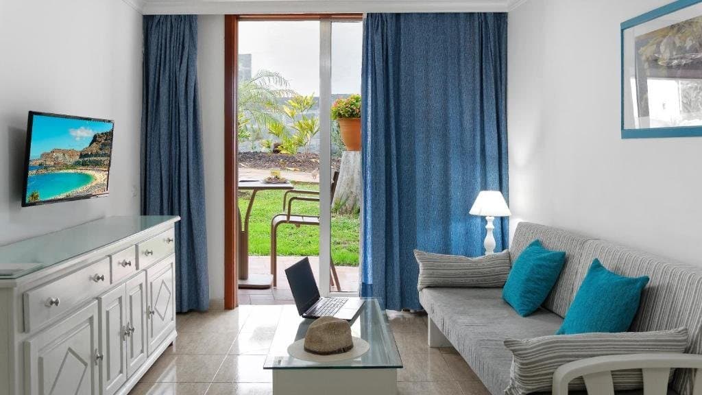 Salon apartamentu z sofą i wyjściem na taras